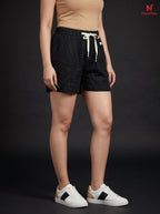 Model wearing black Novelties® pure cotton shorts with a relaxed fit, elastic waistband, and white drawstring.