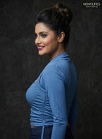 Model wearing a blue Novelties® square neck tube top with an attached long sleeve shrug overlay and ruched detailing.