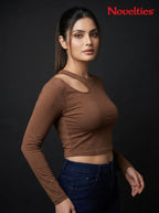 Model wearing a brown Novelties® ribbed long sleeve cropped top with an asymmetric shoulder cutout.