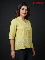 Model wearing a lime green Novelties® mandarin collar shirt with white floral cutwork embroidery at the hem.