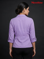 Back view of a woman wearing a Novelties® lavender wrap-style top with notch lapels and three-quarter sleeves.
