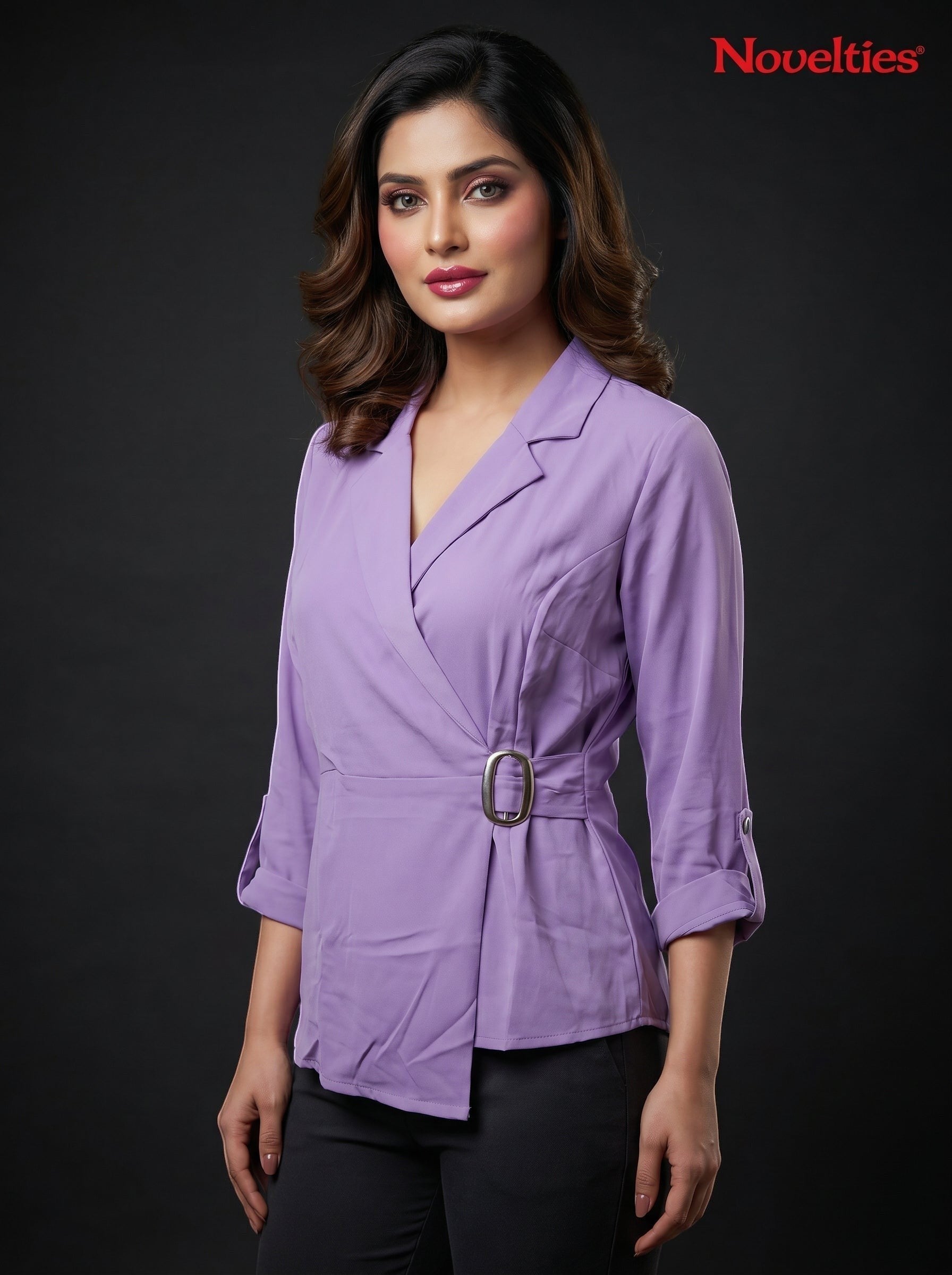 Model wearing a lavender Novelties® wrap-style top with notch lapels, three-quarter sleeves, and a side buckle detail.