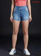 Model wearing Novelties® light blue high-waist denim hot shorts with triple-button closure and raw fray hem.