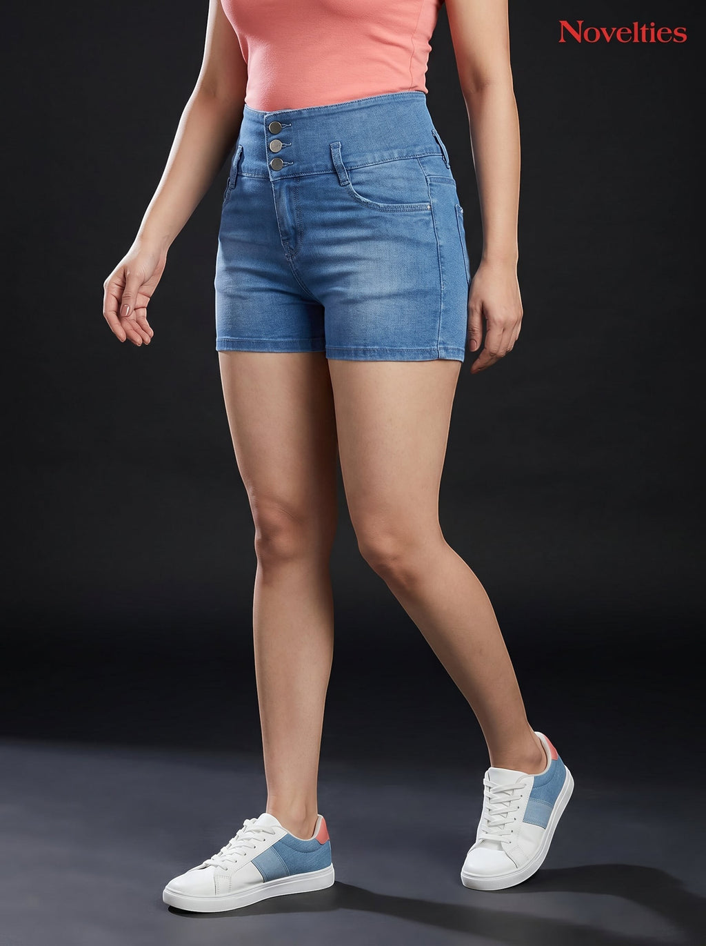 Model wearing Novelties® light blue high-waist denim hot shorts with triple-button closure and casual sneakers.