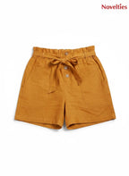 Novelties® mustard pure cotton shorts featuring a paperbag waist, self-tie belt, button placket, and side pockets.