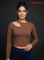Model wearing a brown Novelties® ribbed long sleeve cropped top with an asymmetric shoulder cutout and crew neckline.