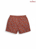 Novelties® rust floral print shorts with a ditsy pattern in blue, yellow, and green on a terracotta base.