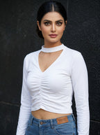 Model wearing a white Novelties® long sleeve cropped top with a choker neck, V-cutout, and centre-front ruching.