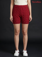 Model wearing Novelties® maroon cable-knit shorts with an elasticated waistband and ribbed hem against black background
