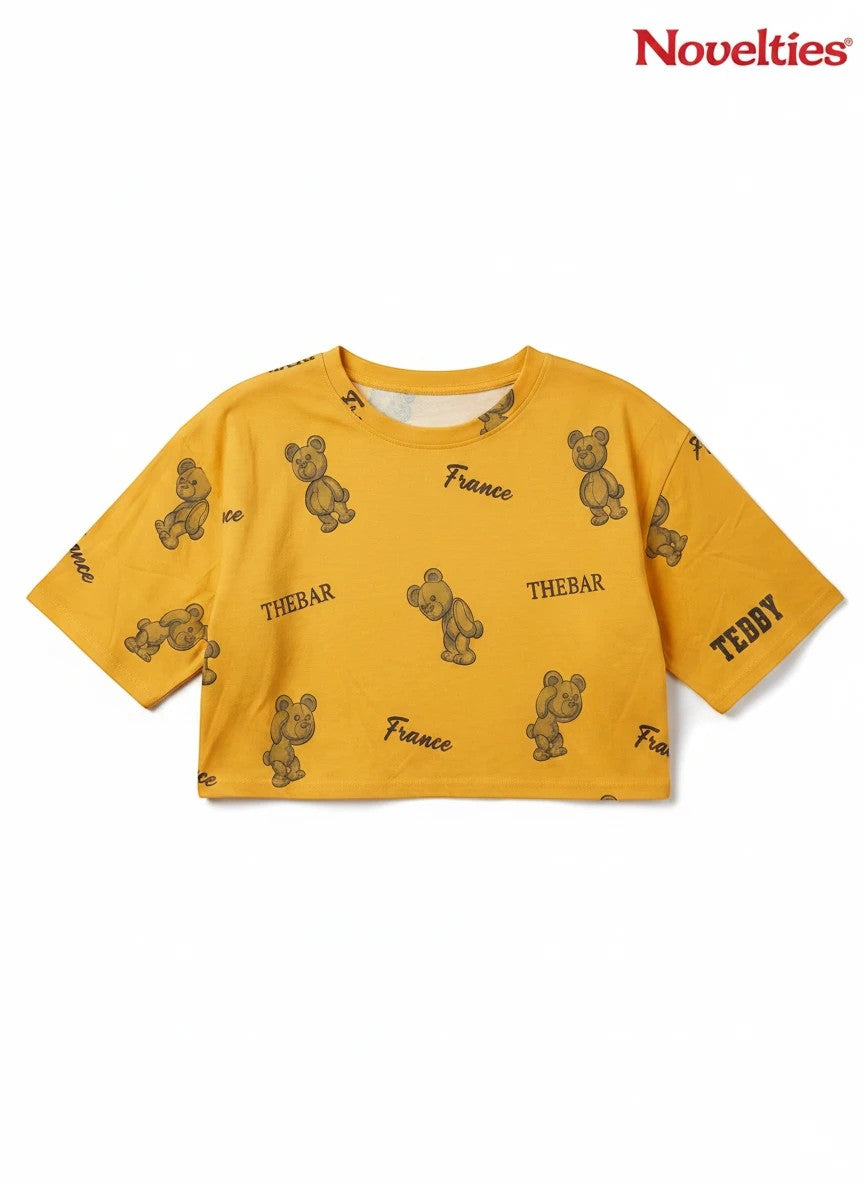 Novelties® mustard yellow crop top with all-over teddy bear graphic print and France typography.