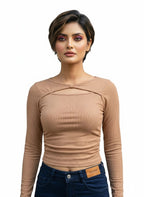 Model wearing a tan Novelties® ribbed long-sleeve crop top with a twist-front cutout and boat neckline.